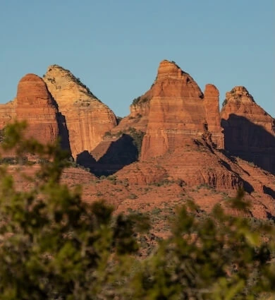 View of Sedona Red Rock Peak with greenery in the foreground.