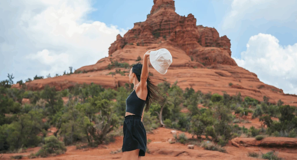 Woman spinning in front of Bell Rock during a Sedona wellness retreat