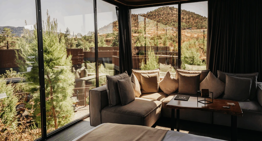 Inside of a private atrium at Ambiente, with a cozy sofa and floor to ceiling windows.