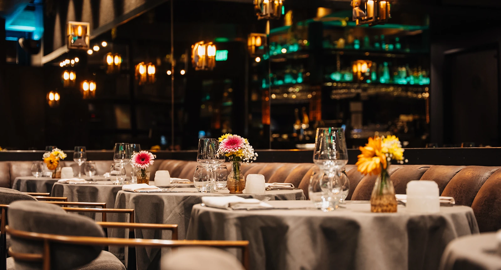 a dimly lit dining area with tables set for dinner
