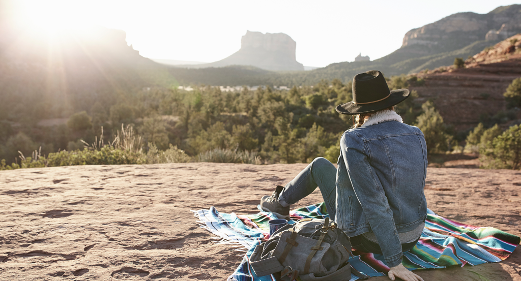 A woman on an Arizona staycation, overlooking the red rocks on a blanket