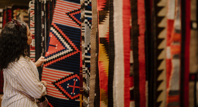 A woman looking at handmade Navajo rugs in Sedona
