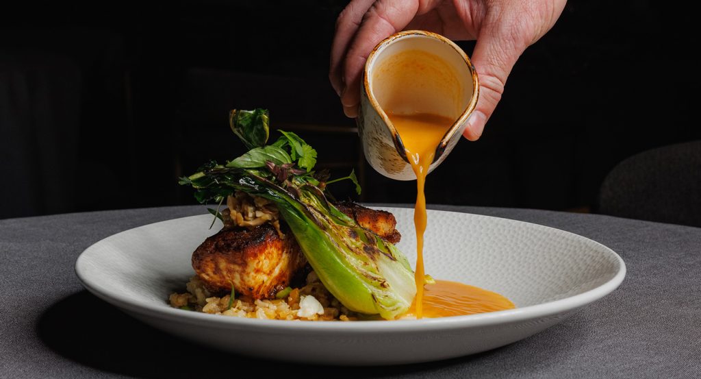 Pouring sauce onto a gourmet dish at Restaurant Forty1